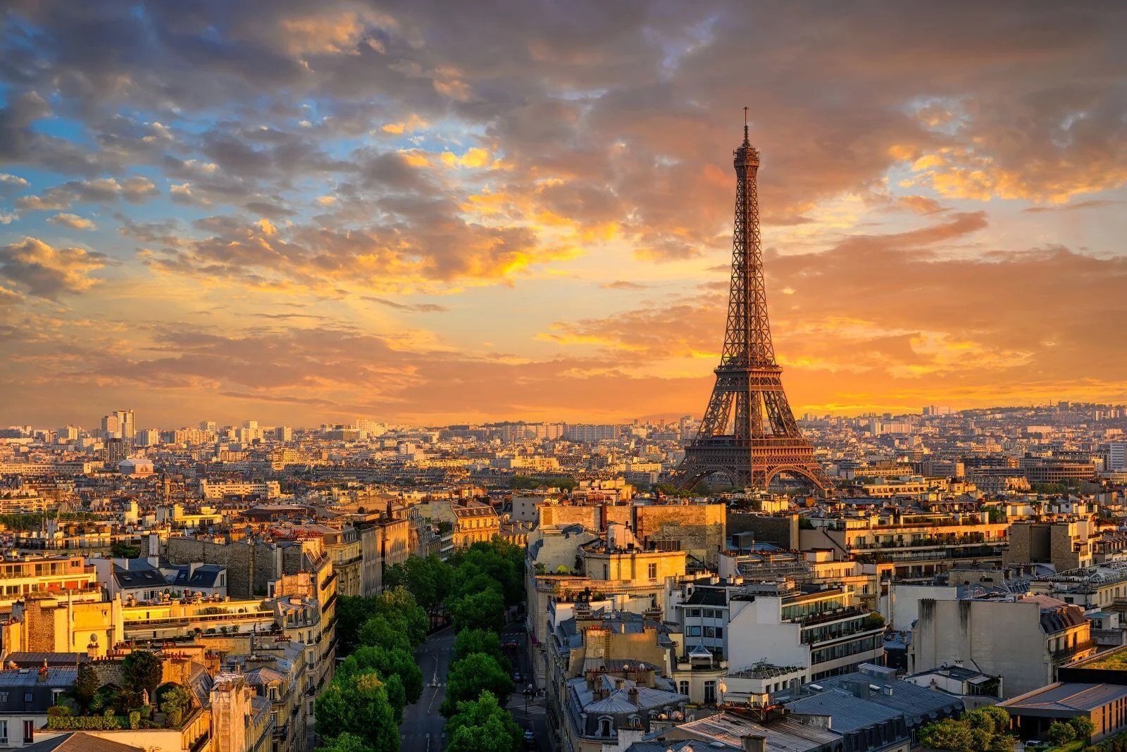 Sunset over Paris with the Eiffel Tower silhouetted against a vibrant cityscape