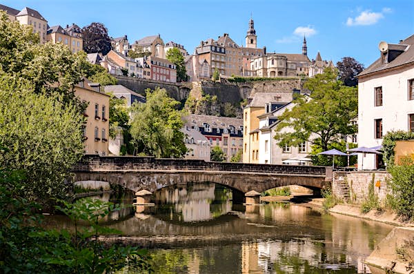 A river flows through a town, flanked by buildings on both sides, creating a picturesque urban landscape